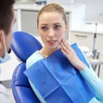 A professional providing TMJ treatment to a female patient